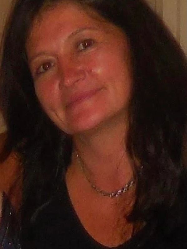 Woman with long dark hair smiling gently at the camera.