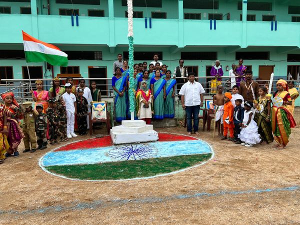 Group celebrates with Indian flag and colors on the ground.