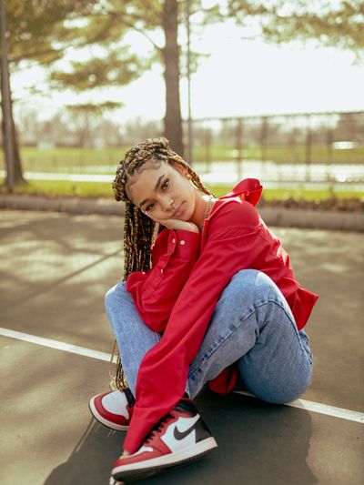 lone teenage girl seated hand on side of face