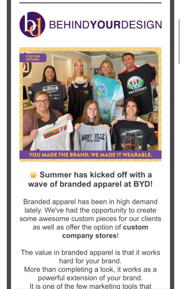 Group holding custom branded apparel with BYD logo.