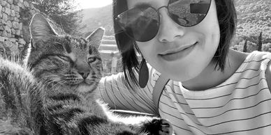 Woman of Asian descent posing with a cat in Ephesus, Turkey
