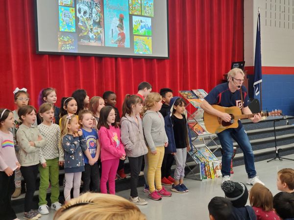 Author Daryl Cobb performs with kids during his "Music & Storytime" Author Visit show.