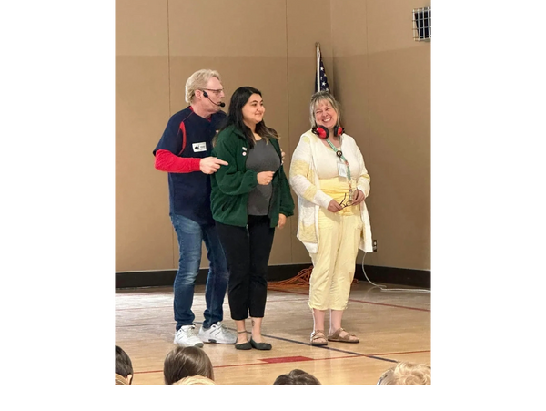 Children's book author Daryl Cobb performing with parents during an author visits program.