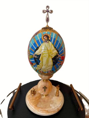 Hand-painted religious egg with Jesus and cross design.