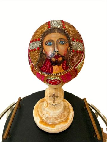 Decorative religious figure with a beaded depiction of Jesus's face.