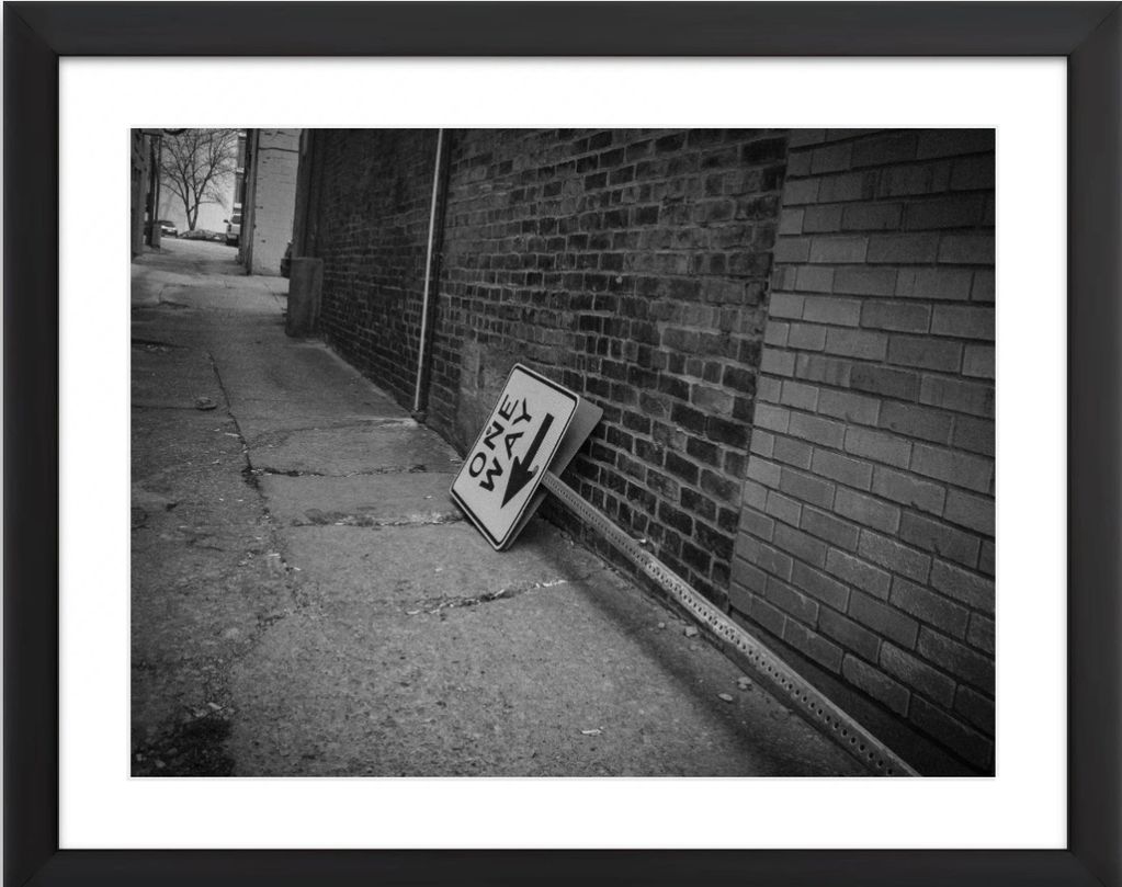 This is a photo of an alley in Downtown Bloomington, Illinois.  A ONE-WAY sign arrow pointed down.