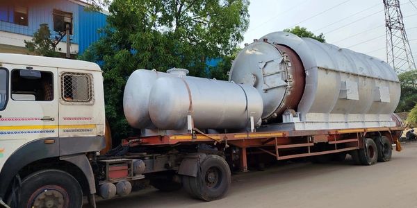 A truck carrying a large industrial cylindrical tank on a flatbed trailer.