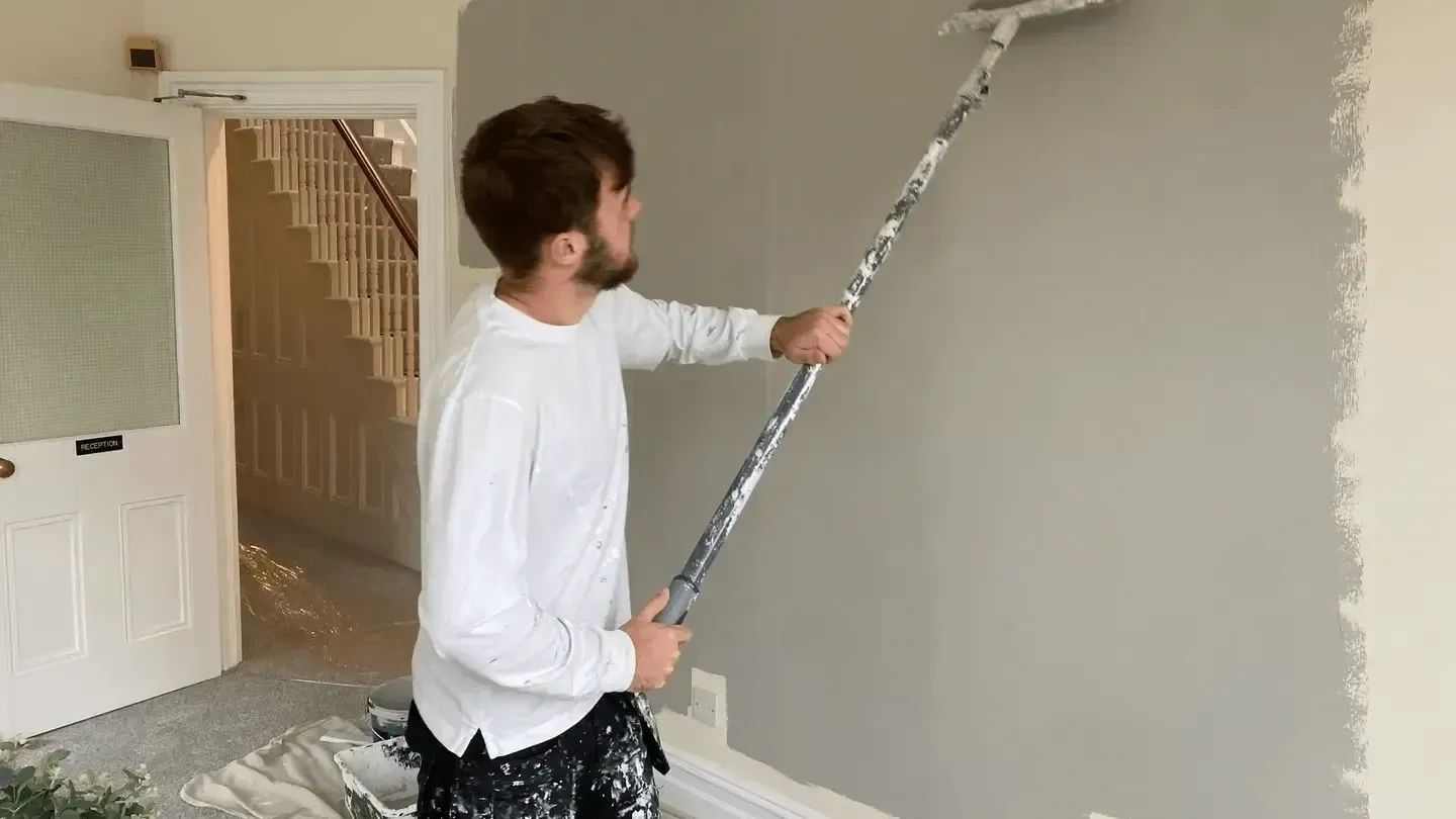 Ryan Smith painter and decorator with paint roller and pole