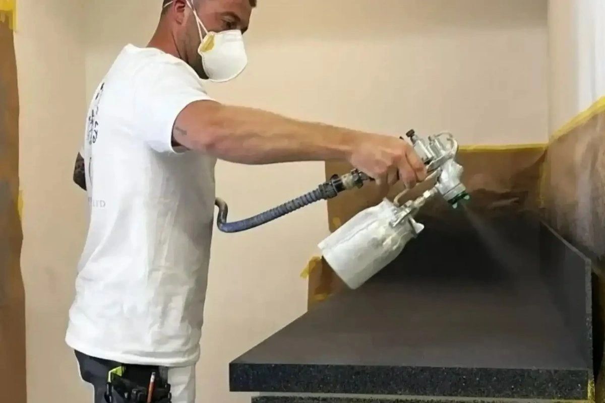 Spray painter painting kitchen units