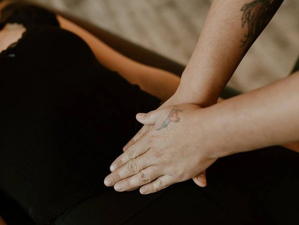 Hands performing a therapeutic massage on a person's back.