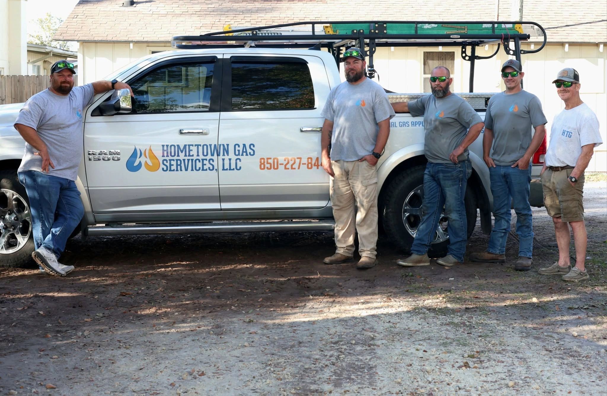 Five men standing by a Hometown Gas Services truck.