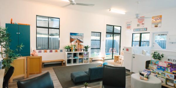 Bright and organized early childhood classroom with various learning areas and furniture.