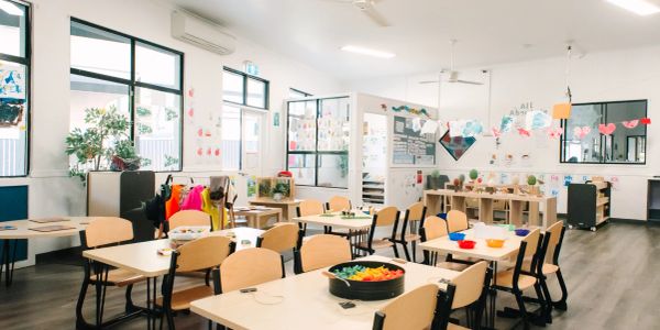 Bright and organized classroom with child-sized chairs and tables.