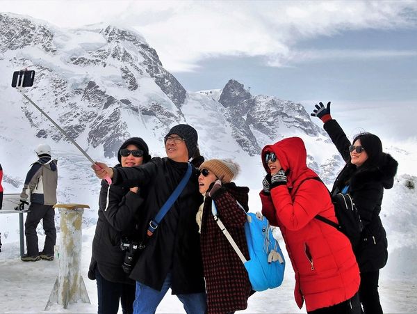 Take a selfie on the top of a mountain with group travel with At Your Beck And Call.