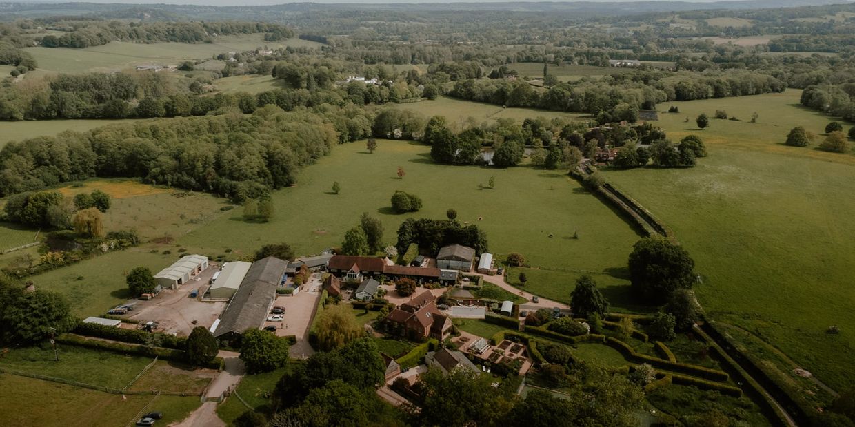 Aerial view of a rural farm with fields and trees.
