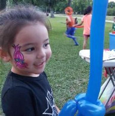 Girl holding balloon sword with princess poppy face painting at jersey village park w/ kids running