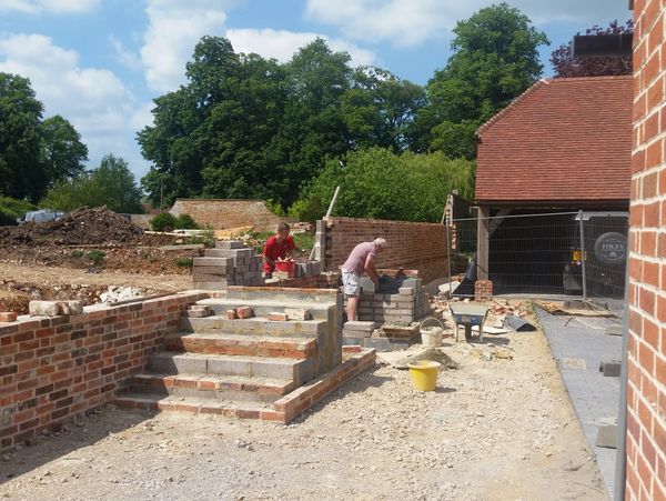 Builders working on layering a brick wall