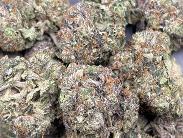 Close-up of dried cannabis buds with visible trichomes and orange hairs.