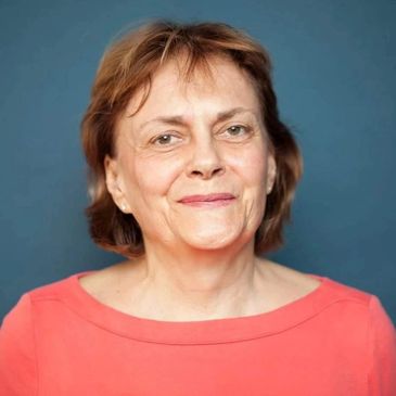 Portrait of a smiling middle-aged woman with short brown hair.