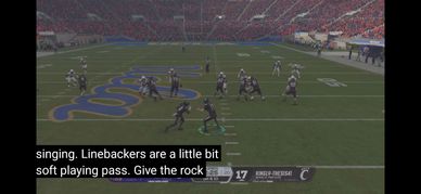 Football game moment with players lined up on the field in a stadium.