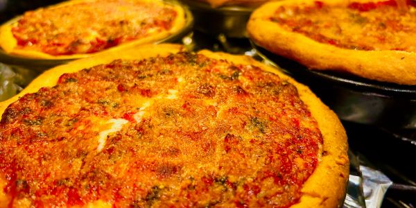 Close-up of three cheese pizzas.