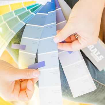 Jessica Gaucher looking at a Sherwin Williams color deck to select colors for a color consultation