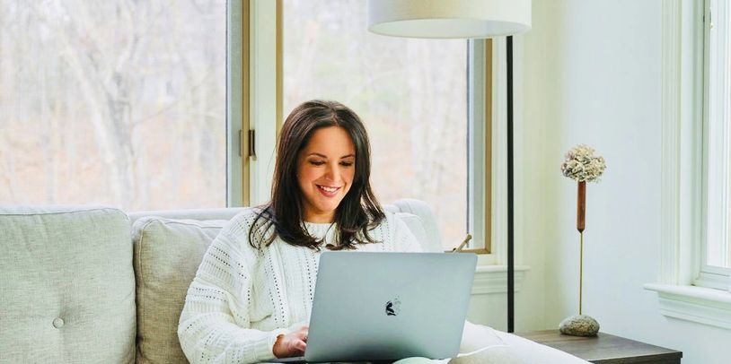 Jessica Gaucher sitting on a couch in her office working on a new client presentation