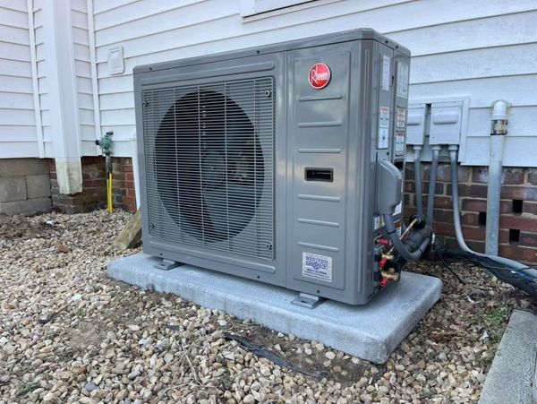 Outdoor Rheem air conditioning unit on concrete pad.