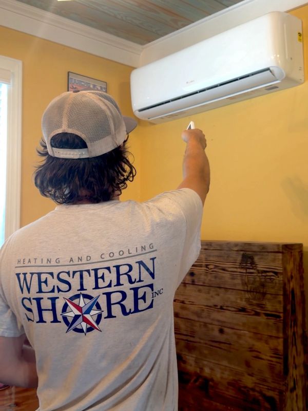 Technician adjusting an indoor air conditioning unit.