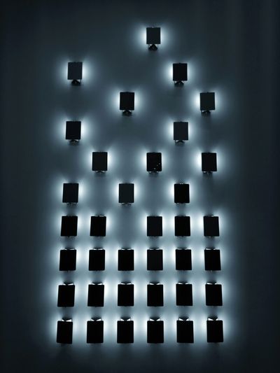 Thirty six decorative black wall sconce cool LED lighting fixtures on a black wall