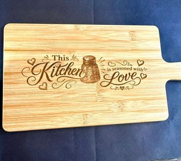 Wooden cutting board with a kitchen love quote.