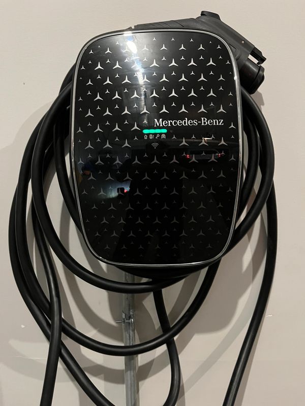 Mercedes-Benz electric vehicle charging station with coiled cable.