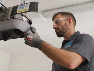 Technician inspecting a Lift Master garage door opener - Garage Door opener Service Rochester NY