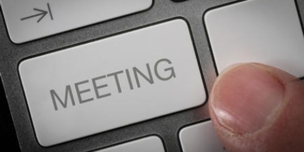 Close-up of a keyboard key labeled 'MEETING' with a finger about to press it.
