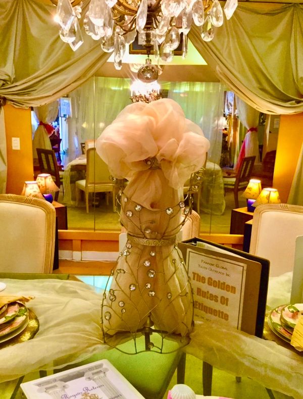 Decorative mannequin with crystals and soft fabric in an elegant dining room.
