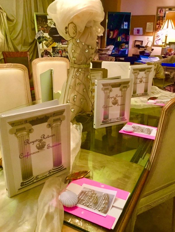 Elegant conference setup with decorative binders and a centerpiece on a glass table.