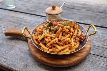 piatto di pasta al ragu di cervo dolomitico delizioso servito su tagliere di legno