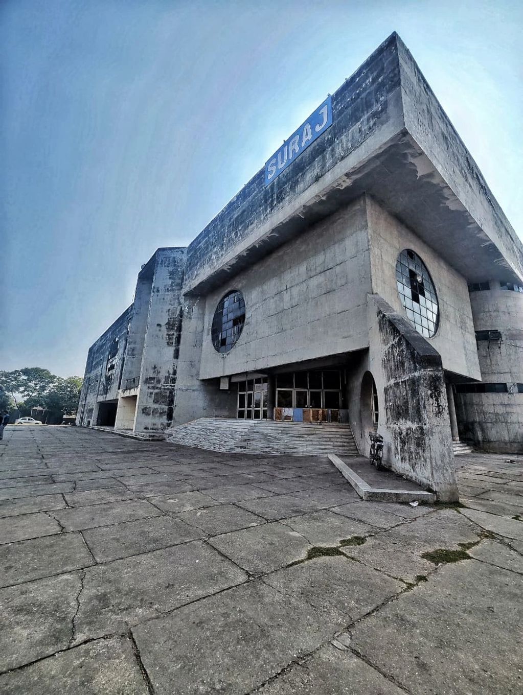 Brutalist concrete building with 'SURAJ' sign.
