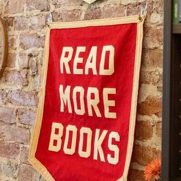 Banner saying 'READ MORE BOOKS' on a brick wall.