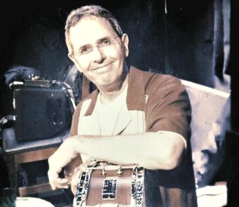 Man smiling while holding a chain handbag.