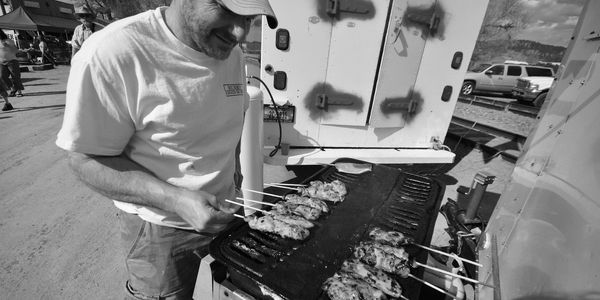 Man at grill during Craig Caddis Festival in central Montana