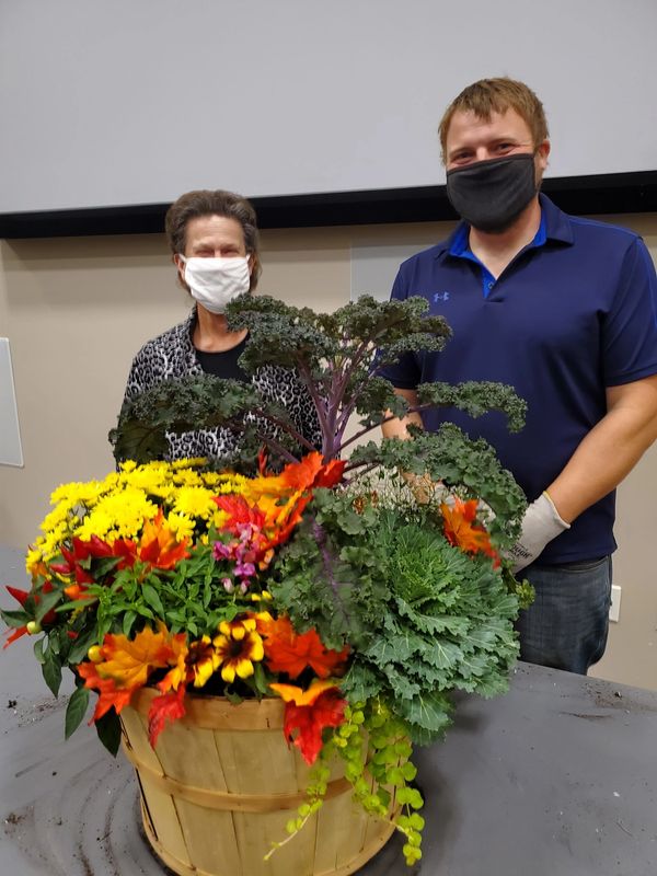 Kayleen Heiniger and fall pot demo presenter pose smiling behind masks with flower pot