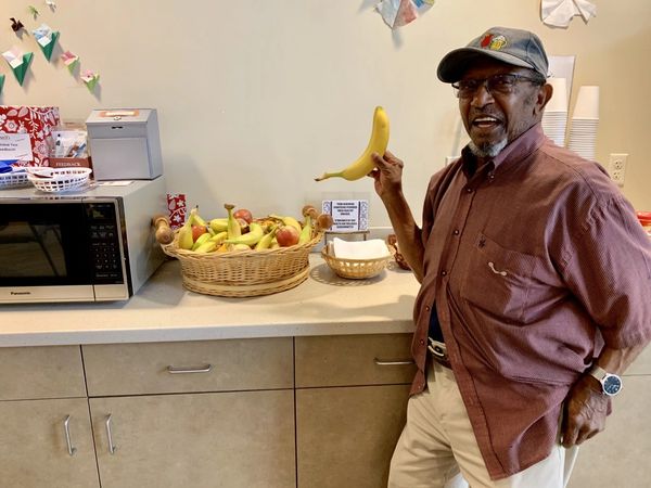 Member James Williams smiles while holding banana in Bonnie's Cafe at ARC