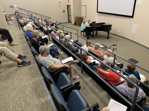 View from top of seating rows in Auditorium as members watch a piano concert for four hands at ARC