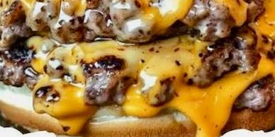 Close-up of a cheeseburger with melted cheese and grilled beef patties.