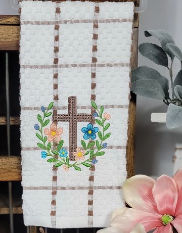 White towel with brown cross and colorful floral embroidery.