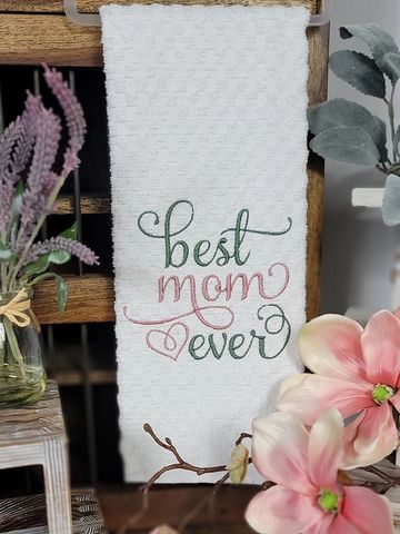 Decorative towel with 'best mom ever' embroidery surrounded by flowers.