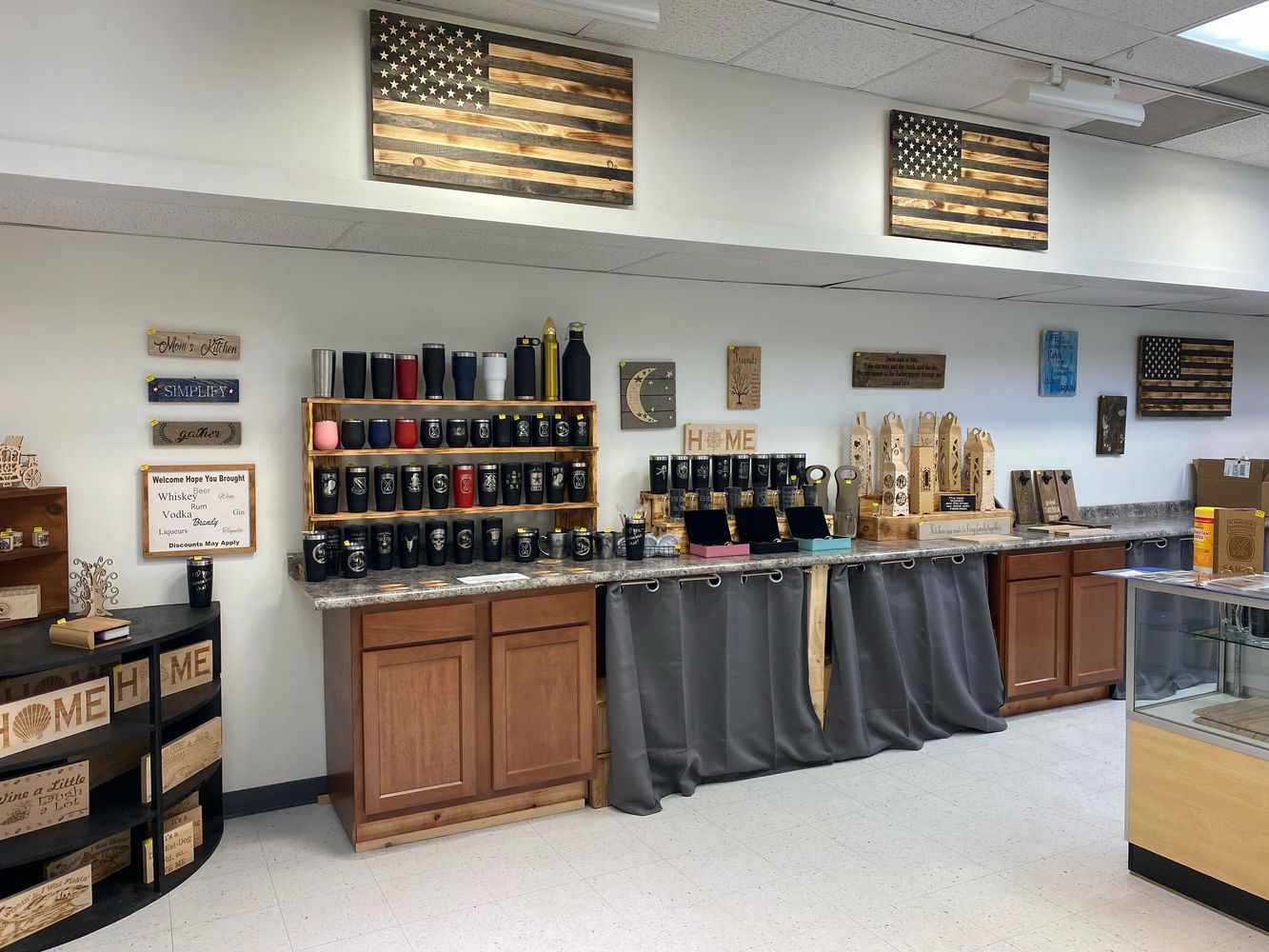 Photo of the shop with mugs, wooden flags, display cases, thermos, and wall decor.