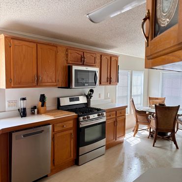 Bright kitchen with wooden cabinets and stainless steel appliances.