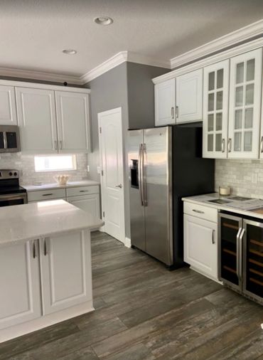 Modern kitchen with white cabinets and stainless steel appliances.
